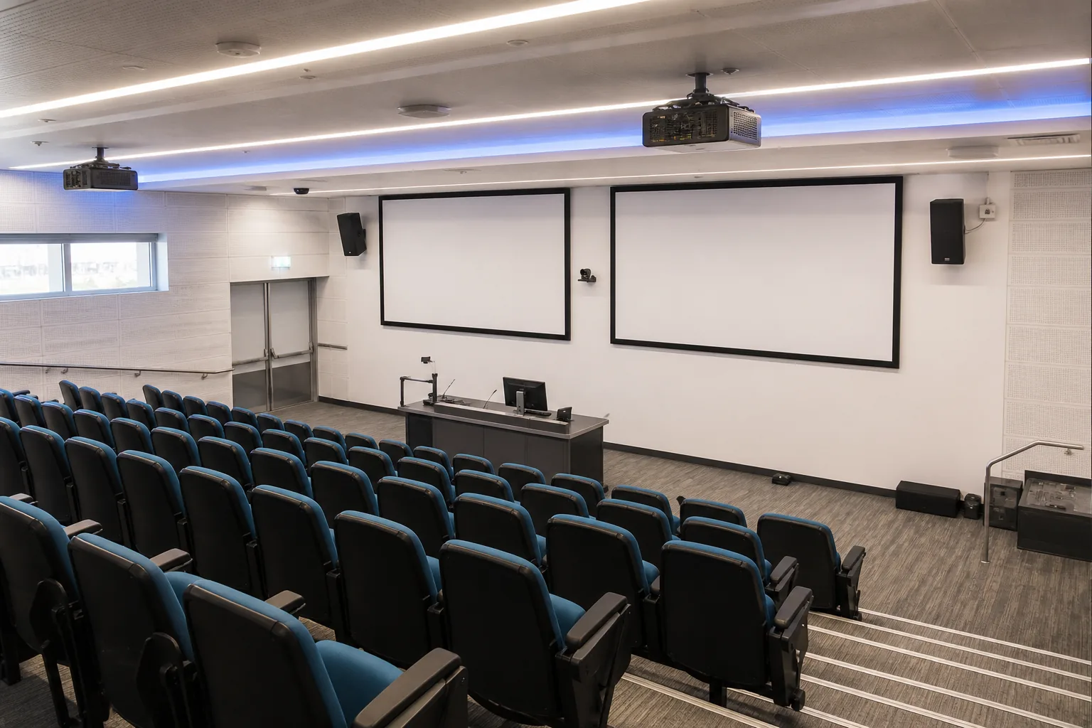 Education auditorium with projection screens, lectern and installed AV